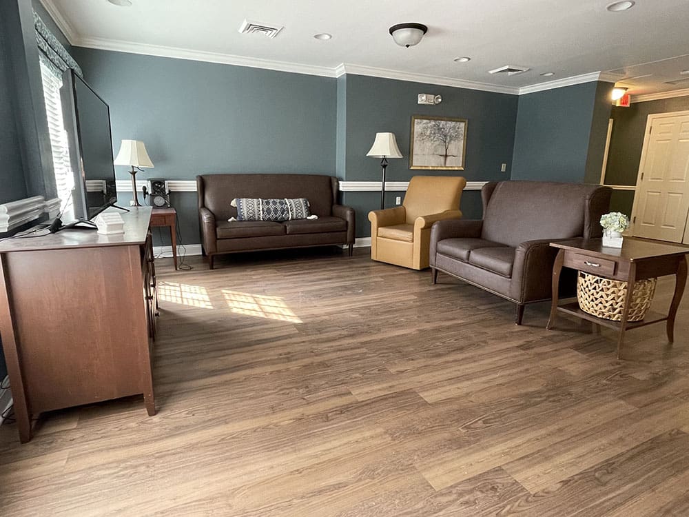 tv area with couches, a chair, and lamps